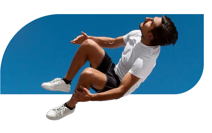 Man doing aerial trick on trampoline under blue sky