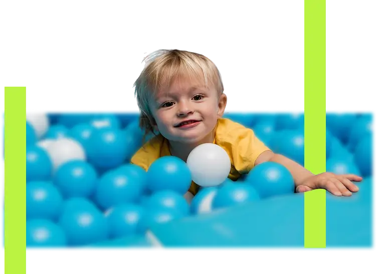 "Happy toddler playing in a blue and white ball pit at an indoor play center."