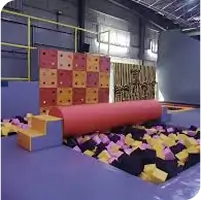 Indoor obstacle course with colorful foam pit and rolling log challenge